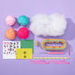 Flat-lay of the Nimble Knitter - Squishee Stuffies craft kit by Bright Stripes on a purple background, featuring four yarn balls, stuffing, an adjustable knitting loom with a bamboo base, tools, felt face stickers, a straw, and pink pipe cleaners—everything you need to create adorable knit characters.