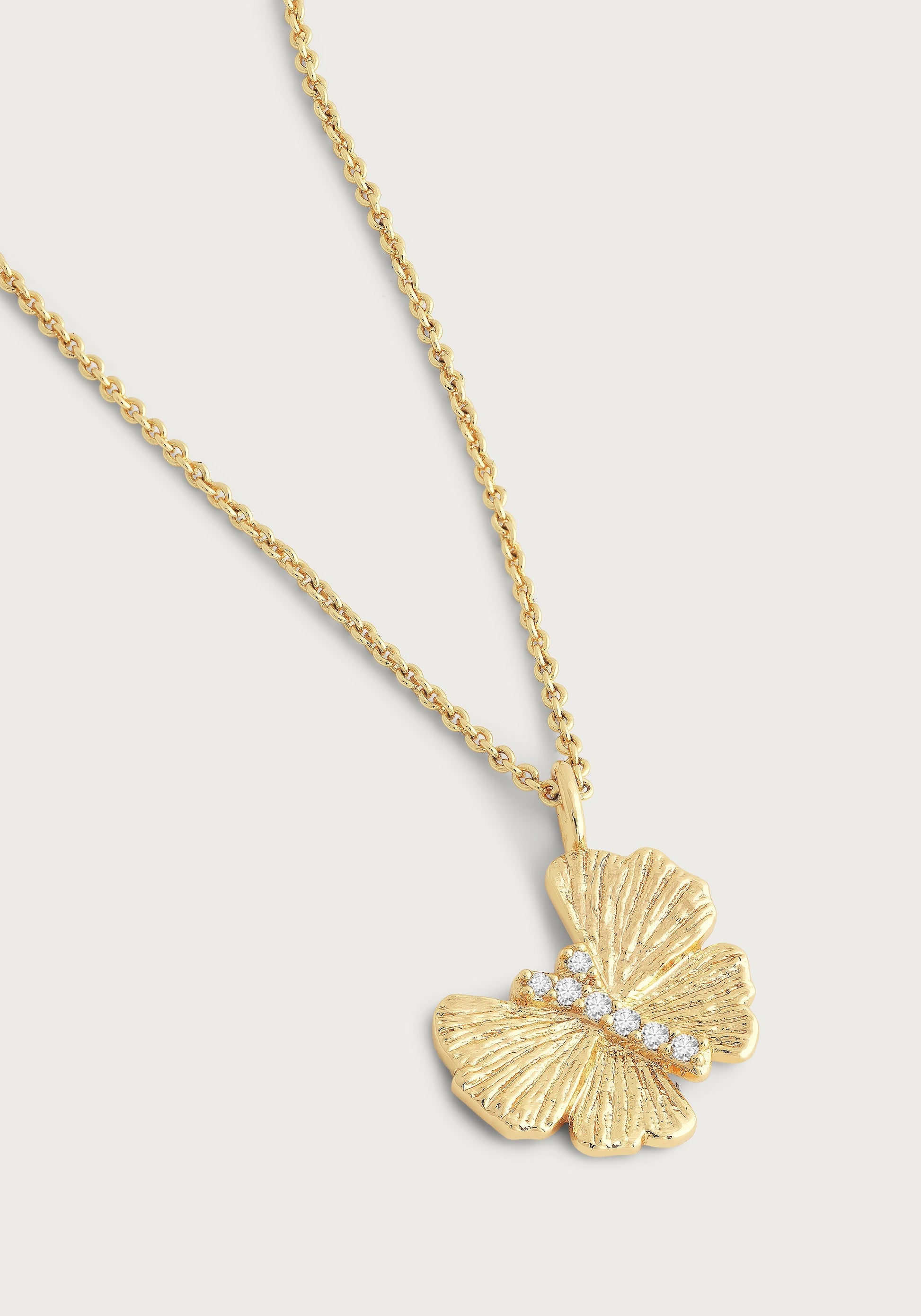 The Anabel Aram Butterfly Gold Necklace features a textured 18k gold butterfly pendant with a diagonal row of hand-set crystals on the wings, shown against a plain background.