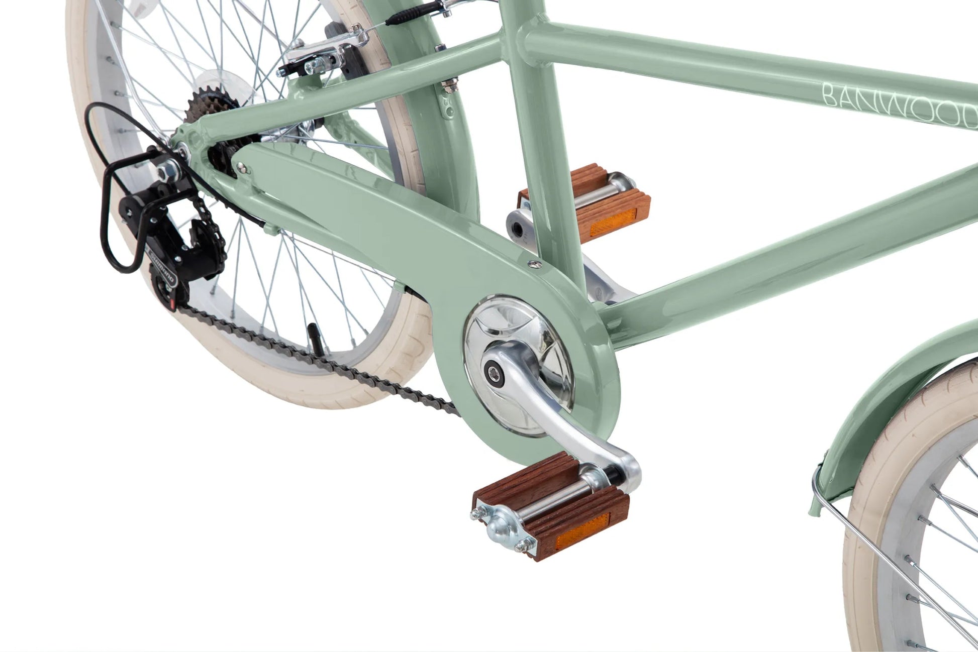 Close-up of a light green Banwood Kids’ Vintage Classic Bike frame, highlighting the pedal, chain guard, gear system, and beige-spoked tires—a stylish children’s seven-speed bicycle that adds vintage charm to young riders’ cycling adventures.