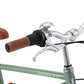 Close-up of a Banwood Kids’ Vintage Classic Bike handlebar featuring a brown rubber grip, gear shifter, silver bell, brake lever, and parts of the green frame and brown seat—perfect for young riders who appreciate classic Scandinavian design.