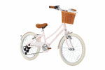 The Banwood Kids’ Vintage Classic Bike features a light pink frame, brown seat and handlebars, white tires, and a wicker basket attached to the front—charming vintage-inspired details thoughtfully crafted in a playful size for young riders.