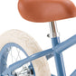 Close-up of the blue Kids’ Vintage First Go Balance Bike by Banwood, featuring a brown seat, chrome seat post, white rear tire, and spokes against a white background.
