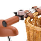 Close-up of the handlebar of the Banwood Kids’ Vintage First Go Balance Bike, featuring a brown leather grip, a small bell, and a wicker basket attached to the front.
