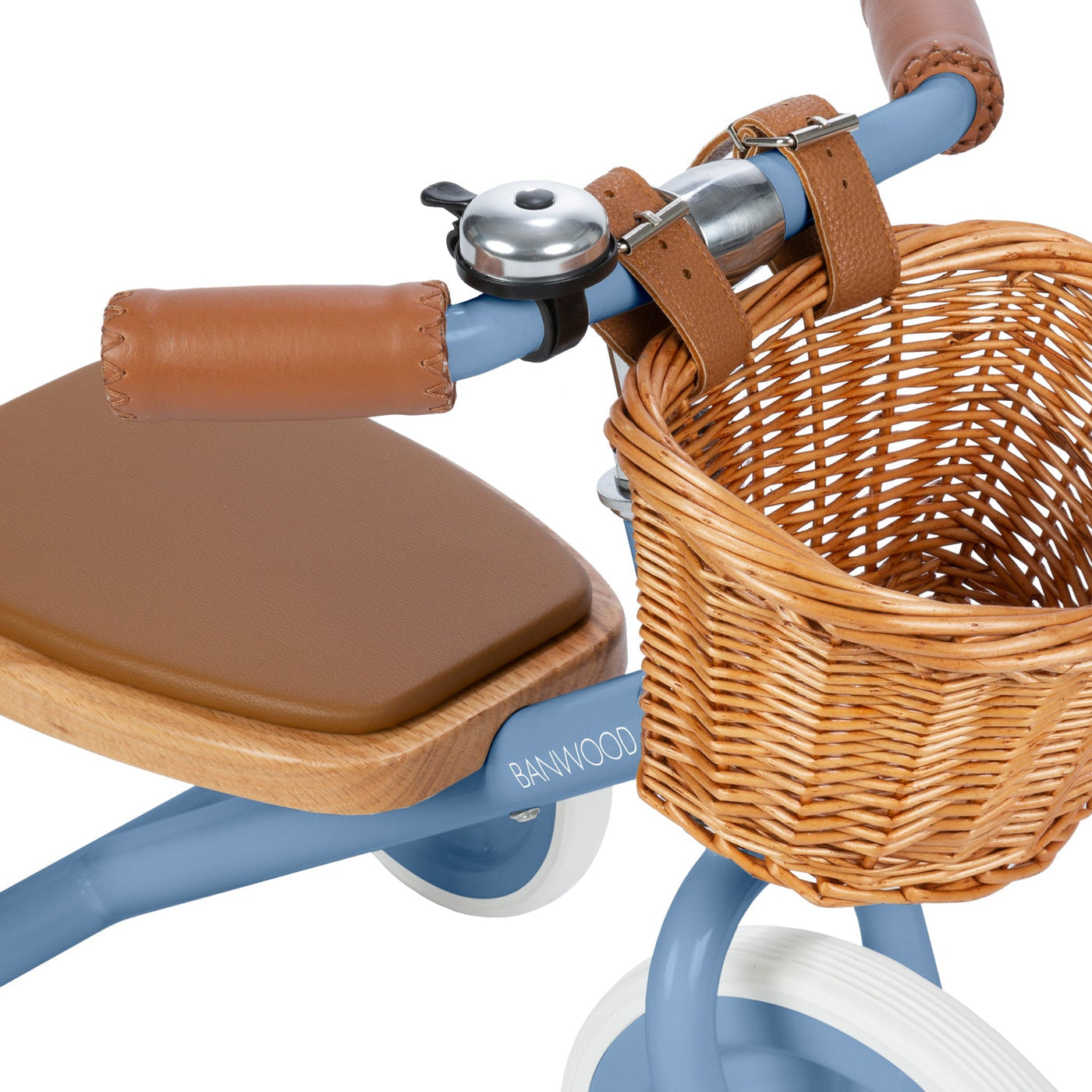 Close-up of the Banwood Kids’ Trike Vintage in blue, showcasing brown leather handlebars, a matching seat, a metal bell, and a woven wicker basket attached to the front.
