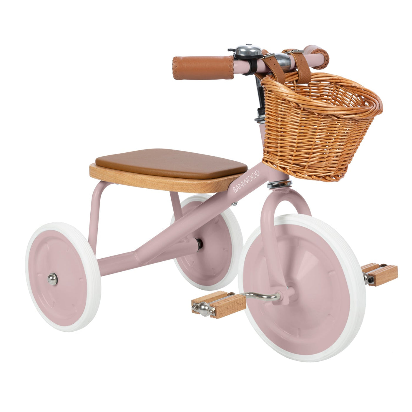 The Banwood Kids’ Trike Vintage is a pink tricycle for children, designed with a brown seat, white wheels, wooden pedals, and a charming wicker basket attached to the handlebars.