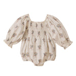 The Noralee Baby Girls' Autumn Romper features a smocked empire bodice, bubbled long sleeves, a square neckline, and a delicate floral pattern in light tones.