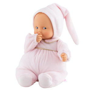 The Corolle Babipouce Sweet Dreams Doll wears a soft pink outfit with matching hat, sits upright sucking its thumb, is cuddly, and machine washable.