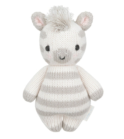 Introducing the Zebra - Baby 7" by Cuddle + Kind, a hand-knit baby animal crafted from heirloom-quality Peruvian cotton yarn. This plush toy showcases gray and white stripes, small ears, black eyes, a smiling mouth, and a tuft of yarn hair on top—making it a charming keepsake to treasure for years to come.