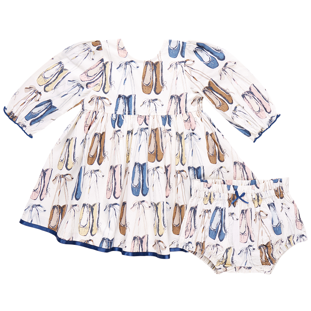 The Pink Chicken Baby Girls' Amma Dress by Pink Chicken is a charming white cotton poplin baby dress that comes with a matching bloomer, both beautifully adorned with ballet slippers in an array of colors. This lovely outfit is perfect for your little dancer!