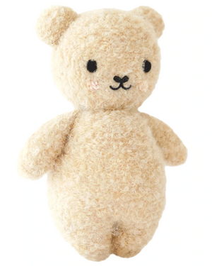 The Baby Boucle Bear - Honey by Cuddle + Kind is a beige, textured plush teddy crafted from heirloom-quality Peruvian cotton yarn, with black eyes, a stitched nose and mouth, and softly blushed cheeks.