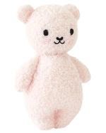 The Baby Boucle Bear - Strawberry by Cuddle + Kind is a pale pink plush teddy crafted from heirloom-quality Peruvian cotton yarn, with black embroidered eyes and nose, rounded ears, and a minimalist design.
