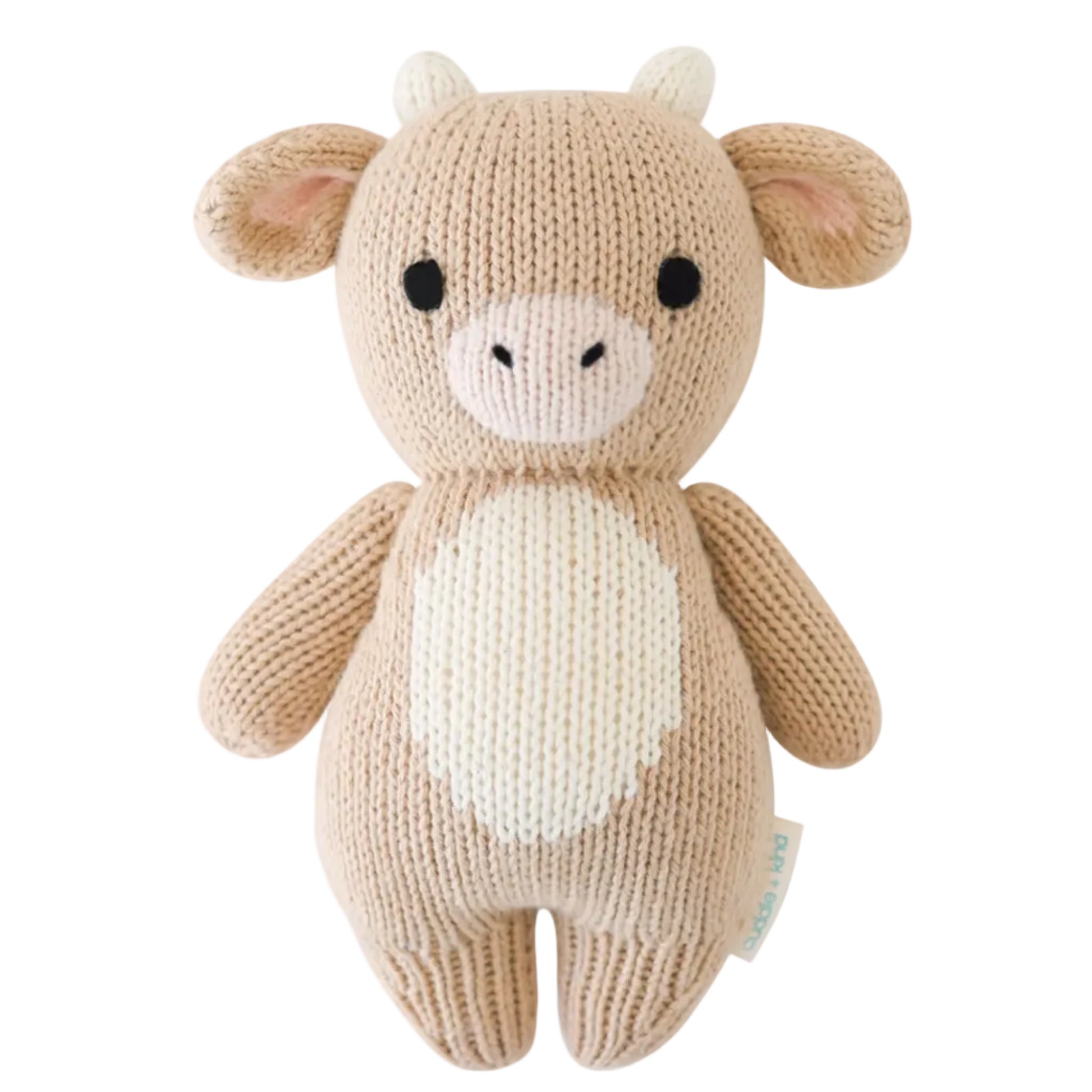 Introducing the Baby Cow by Cuddle + Kind—a beige, handcrafted plush toy made from natural cotton yarn, featuring small horns, round black eyes, and a white belly. This adorable cow is displayed against a white background.