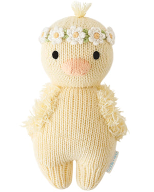 The Baby Duckling Ivory Floral by Cuddle + Kind is a handcrafted, heirloom-quality plush toy with black eyes, a peach beak, and a white floral crown, shown against a plain white background.