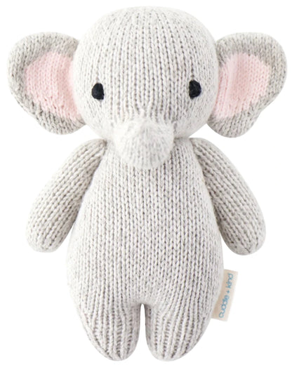 The Baby Elephant by Cuddle + Kind is a hand-knit plush toy crafted from heirloom-quality Peruvian cotton yarn, featuring large ears, black eyes, and a soft texture. Shown on a plain white background.