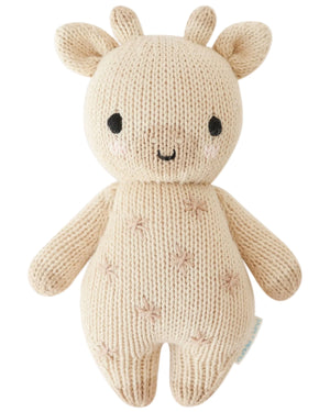 The Baby Giraffe by Cuddle + Kind is a beige knitted plush giraffe made from heirloom-quality Peruvian cotton yarn, with stitched facial details, small horns, and a cheerful smile.
