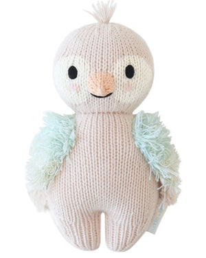 Introducing the Mauve Parrot - Baby 7" by Cuddle + Kind, a handcrafted, knitted stuffed animal featuring light pink plumage, mint green wings, black eyes, a small beak, and a sweet tuft on its head.