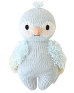 The Sky Blue Parrot - Baby 7" by Cuddle + Kind is a knitted stuffed animal shaped like a bird, featuring light blue heirloom-quality Peruvian cotton yarn, a white face, tufted head, and fluffy wings—shown on a white background.