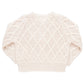 The Pink Chicken Girls' Katrina Sweater by Pink Chicken, featuring a beige color, long sleeves, a knitted design with a diamond pattern, and glitter button closure, is laid flat on a white background.