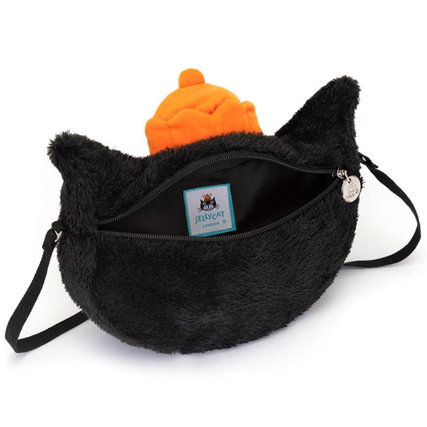 The Jellycat Bag by Jellycat is a fuzzy black bag shaped like a cat with liquorice fur, featuring a visible zipper pocket and a bright orange interior. A small tag inside reads "Jellycat London" along with the logo. The bag is equipped with a thin webbed cross-body strap for easy carrying.