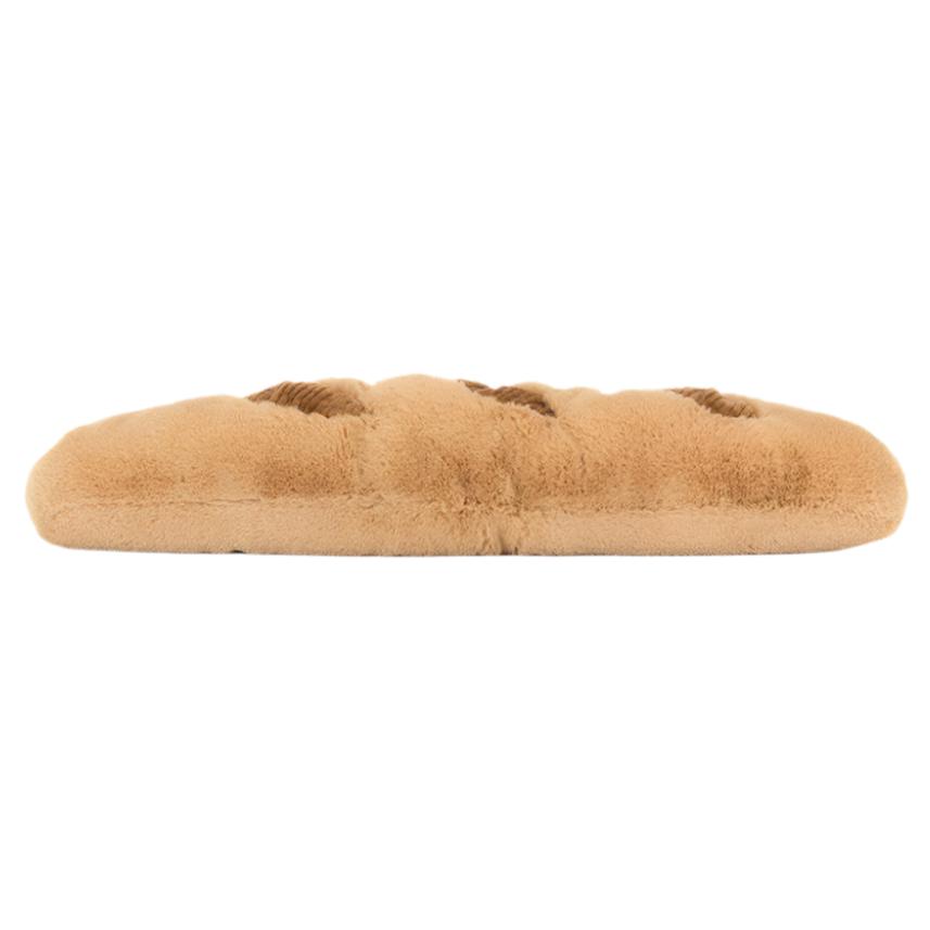 A Jellycat Amuseables Baguette, a plush toy shaped like a golden loaf of bread, laying flat and irresistibly huggable.