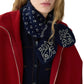 A person wearing a red coat, navy blue shirt, and the Bandana Bowtie Scarf with white designs from Guest in Residence.