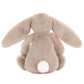 The Jellycat Bashful Beige Bunny, Small, sits facing away with long floppy ears and a white tail—a charming plush gift.