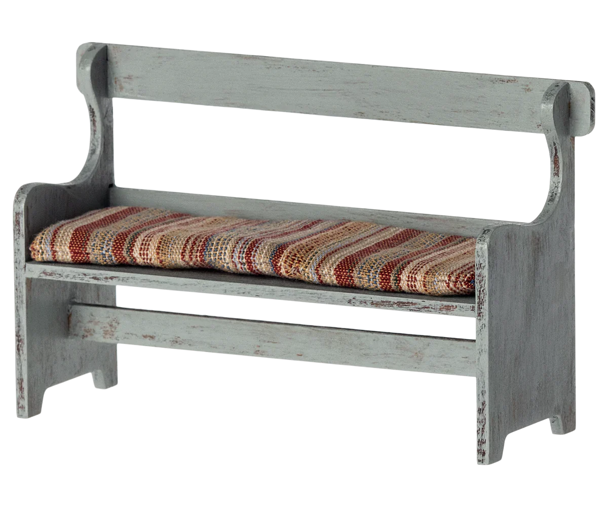 The Maileg Bench, Mouse by Maileg is a small, rustic wooden bench with a distressed finish and a cushioned seat covered in striped fabric—perfect for adding a touch of Mouse Hole Farmhouse charm to your decor.