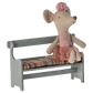 A Maileg fabric mouse doll in a pink outfit sits on the charming Maileg Bench, Mouse with a colorful striped cushion, perfect for adding charm to your Mouse Hole Farmhouse.