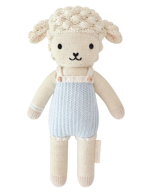 Benjamin the Lamb - Little 13" by Cuddle + Kind is a charming plush toy with cream-colored wool, black eyes, and a blue romper, shown on a white background—a perfect gift for kids.