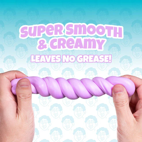 Two hands stretch a twisted, pastel purple, clay-like substance—Better Butter - Berry Thinking Putty by Crazy Aaron’s—perfect for sensory play. Text above reads, “Super smooth & creamy. Leaves no grease!” Cartoon faces make up the playful background pattern, while a hint of berry scent makes this putty extra delightful.