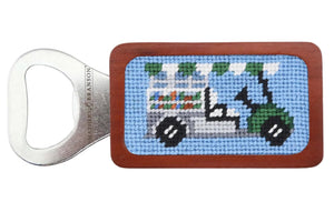 The Smathers & Branson Beverage Cart Bottle Opener features hand-stitched needlepoint with a golf cart on blue and a wooden handle.