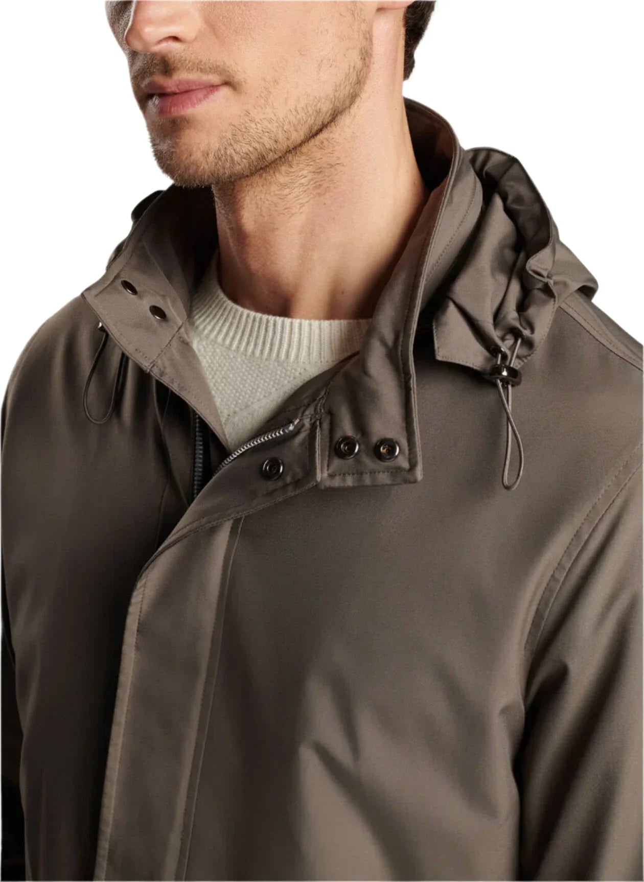 A person wearing the Peter Millar Discovery Field Jacket with a hood and a white sweater underneath.