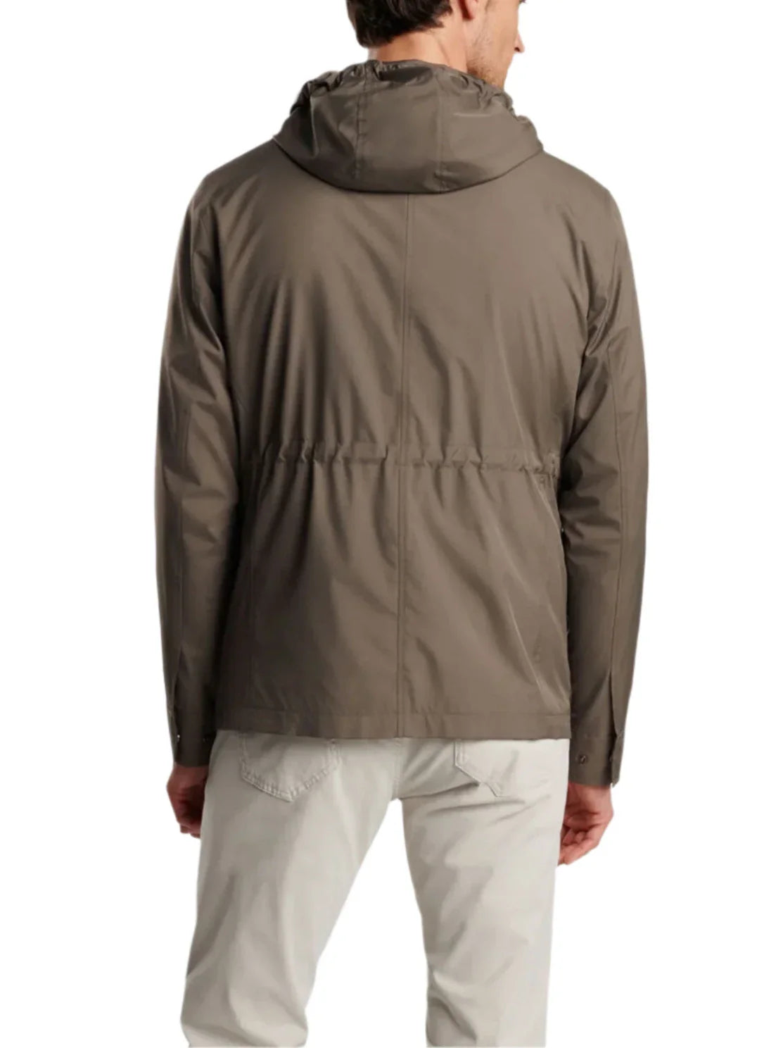 A man is seen from the back wearing a Peter Millar Discovery Field Jacket, expertly crafted from performance twill, paired with light gray pants.