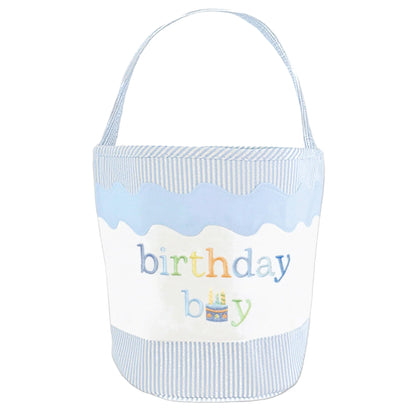 The Birthday Boy Tote by Bits & Bows features light blue and white stripes, a handle, "birthday boy" embroidery, and a cute cake illustration—ideal for gifting or charming toy storage.