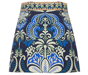 The Blaze Skirt by Cara Cara showcases a chic blue, white, and green floral A-line design with a woven tan raffia belt waistband.