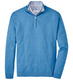 The Peter Millar Coolspun Cotton Quarter-Zip Sweater is a breathable garment featuring a blue hue with a plaid lining in the collar.