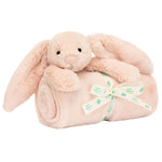 A soft beige Jellycat Bashful Blush Bunny Blankie from Jellycat sits atop a rolled-up beige baby blanket, crafted from recycled fibers and tied with a white ribbon labeled "Baby Blush." This adorable set makes the perfect baby gift.