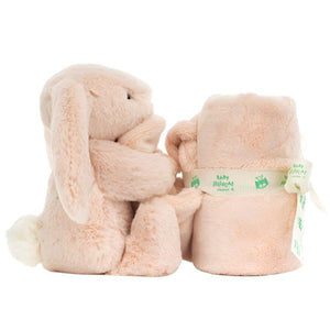 The Jellycat Bashful Blush Bunny Soother, crafted from recycled fibers, holds a rolled-up baby blanket tied with a delicate ribbon.