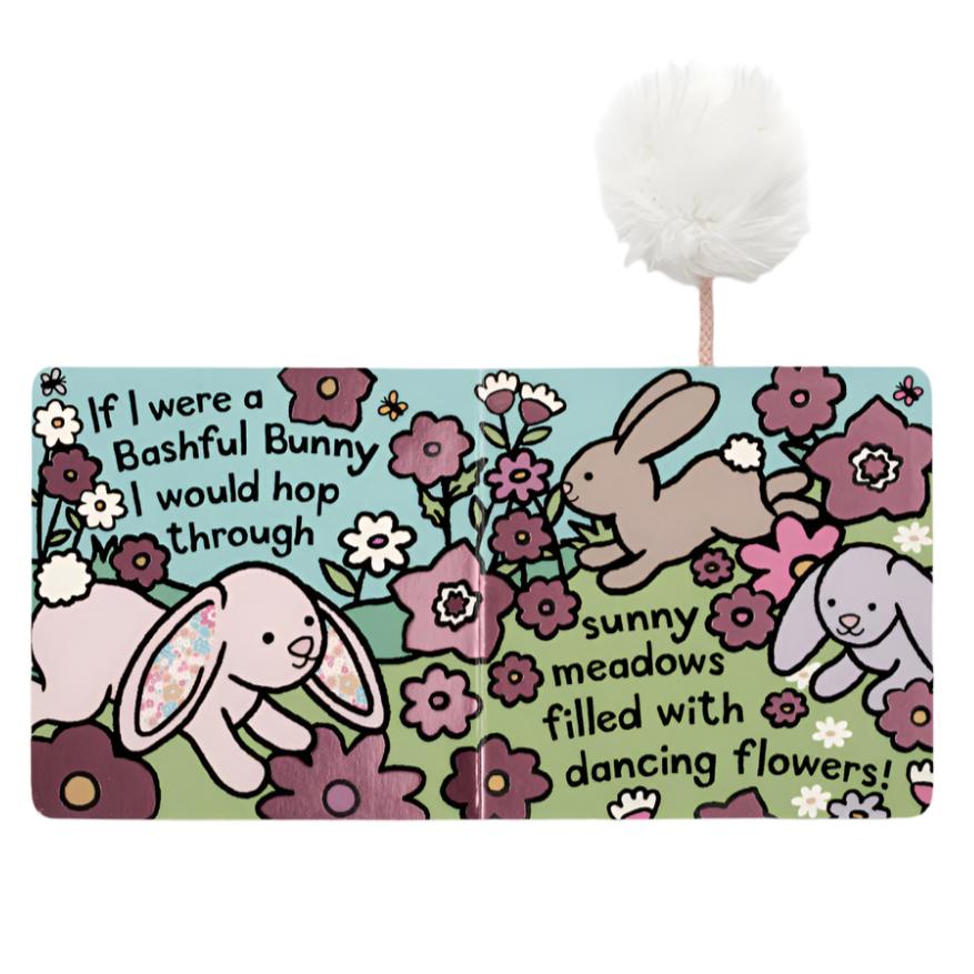 An illustrated page from the Jellycat If I Were a Bunny Book - Blush depicts two bunnies hopping through a meadow filled with flowers. The text reads: "If I were a Bashful Bunny, I'd hop through sunny meadows filled with dancing flowers—a perfect sensory treat for newborns!