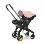 The Doona Car Seat and Stroller by Doona is a stylish black and pink travel system that combines a car seat mounted on a four-wheel frame with an easy-to-use handlebar, providing an ideal mix of style and functionality.