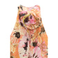 The Floral Dream Dress by Dorothee Schumacher is a sleeveless A-line dress in pink, yellow, and orange floral print, featuring a large fabric flower at the neckline.