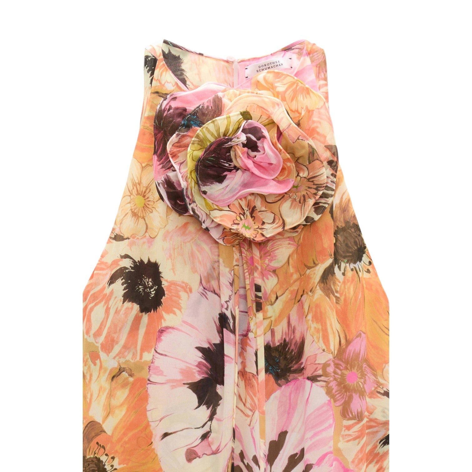 The Floral Dream Dress by Dorothee Schumacher is a sleeveless A-line dress in pink, yellow, and orange floral print, featuring a large fabric flower at the neckline.