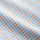 Close-up of the Johnnie-O Shay Button Down featuring a wrinkle-resistant twill fabric with a blue and white checkered pattern, accented by thin orange lines creating a grid.