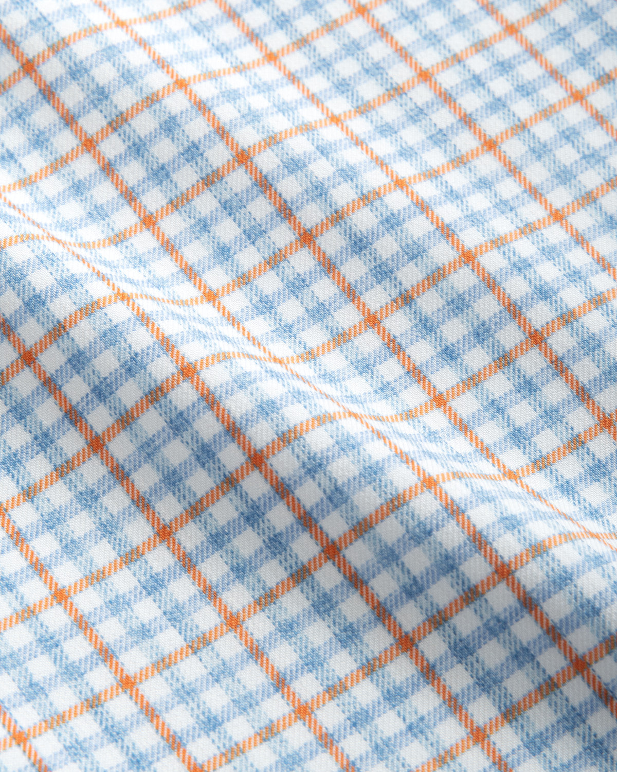 Close-up of the Johnnie-O Shay Button Down featuring a wrinkle-resistant twill fabric with a blue and white checkered pattern, accented by thin orange lines creating a grid.