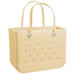 A beige, rectangular Original Bogg Bag tote from Bogg Bags with perforated sides and two sturdy handles. The bag has circular holes arranged in rows, and the brand name "bogg" is embossed on the lower right corner. Known for its durable tote and washable design, it's as practical as it is stylish.