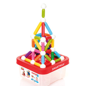 A colorful structure built from Smart Games' SmartMax Build XXL pieces sits atop a storage container with a red lid labeled "SMARTMAX.