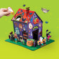 A hand places a glow-in-the-dark ghost sticker onto a Make Your Own Haunted House cardboard playset, perfect for imaginative play with Halloween-themed cutouts.