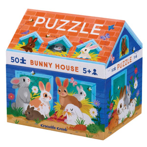 The Crocodile Creek Bunny House 50 Piece Puzzle comes in a vibrant, house-shaped box adorned with illustrations of various bunnies. This educational puzzle, designed to improve hand-eye coordination, is ideal for children aged 5 and up.