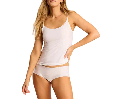 A person wears a Commando Butter Cami with adjustable straps and white boyshort underwear, standing with one hand on their hip against a white background.