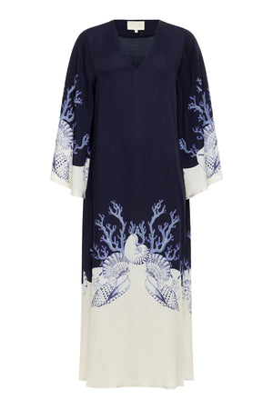 The Lena Kaftan by Carolina K is a navy and white long-sleeve dress featuring marine-inspired shell and coral prints along the hem and sleeves—a stunning artist collaboration with Felicity Buchanan.